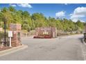 Community entrance featuring brick signage and wrought iron gates surrounded by landscaped greenery, welcoming residents to The Hamptons at 2004 Wild Indigo Circle Nw # 111, Calabash, NC 28467