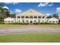 Elegant building featuring multiple columns, balconies, manicured landscaping, and a grand entrance, perfect for a luxurious lifestyle at 2004 Wild Indigo Circle Nw # 111, Calabash, NC 28467