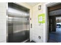 An elevator in a hallway with notice board on the wall and a peek into a doorway showing a vehicle wheel at 210 N Ocean Blvd. # 234, North Myrtle Beach, SC 29582