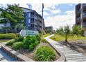 Community sign surrounded by landscaped plants and a wooden walkway for Tilghman Beach and Racket Club at 210 N Ocean Blvd. # 234, North Myrtle Beach, SC 29582