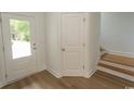 Bright entryway with white trim, a glass door, and hardwood floors leading to the staircase at 2212 Dykman Circle, Little River, SC 29566