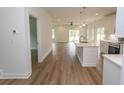 Open-concept kitchen featuring hardwood floors, an island sink, and stainless steel appliances leading to a living area at 2212 Dykman Circle, Little River, SC 29566