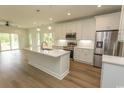Modern kitchen featuring a large island, stainless steel appliances, and white cabinetry against hardwood floors at 2212 Dykman Circle, Little River, SC 29566