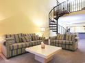 Inviting living room with sofas, a coffee table, and a distinctive spiral staircase at 223 Maison Dr. # D-16, Myrtle Beach, SC 29572