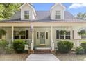 Inviting front porch with ferns, brick steps, and a decorative door at 228 Hopeland St., Pawleys Island, SC 29585