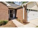 Close up of a brick entryway with a screen door and attached two-car garage at 2405 Brick Dr., Longs, SC 29568