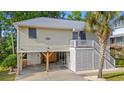 Charming raised beach home with carport, stairs to porch and decorative crab at 265 South Causeway Rd., Pawleys Island, SC 29585