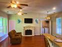 Cozy living room with a fireplace, ceiling fans, and a view of the dining counter at 265 South Causeway Rd., Pawleys Island, SC 29585
