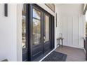 Close-up of elegant black double front doors featuring a glass panel design and sleek hardware, welcoming you home at 28 William Screven Ln., Georgetown, SC 29440
