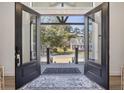 Grand entryway with open glass doors showcasing a picturesque view of the neighborhood and an inviting front porch at 28 William Screven Ln., Georgetown, SC 29440