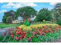 Landscaped entrance to Crow Creek Golf Club with colorful flowers and trees at 290 Woodlands Way Nw # 10, Calabash, SC 28467