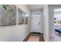 Inviting hallway with wood floors, light gray walls, and decorative wall art, leading to a bright entryway at 311 Glade Ct., Loris, SC 29569