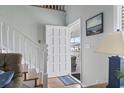 Bright entryway with hardwood floors, white staircase, and an open front door at 312 47Th Ave. N, North Myrtle Beach, SC 29582