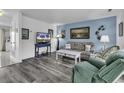 Bright living room with light blue wall, TV, gray wood floors, and comfortable seating at 405 N Hillside Dr. N # C3, North Myrtle Beach, SC 29582