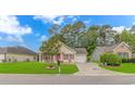 Inviting single-Gathering home featuring well-maintained landscaping, a covered front porch, and an attached one car garage at 409 Hunley Ln., Myrtle Beach, SC 29577