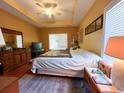 Bright bedroom featuring a tray ceiling, a large bed, and a window to allow natural light at 4266 Arabella Way, Little River, SC 29566