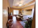Spacious bedroom with a tray ceiling, a large bed, and a window offering natural light at 4266 Arabella Way, Little River, SC 29566
