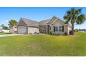 Well-maintained home featuring lush green lawn and mature palm trees on a sunny day at 509 Fallen Leaf Ct., Myrtle Beach, SC 29588