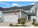 Townhome exterior with neat landscaping, attached garage, and an American flag display at 5371 Knobcone Loop # D, Myrtle Beach, SC 29577
