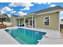 Backyard swimming pool with a covered patio area that includes outdoor seating and an outdoor kitchen with grill at 561 Irees Way, Longs, SC 29568