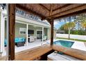 A covered outdoor kitchen is visible from the tiki bar in this backyard with a swimming pool and patio at 561 Irees Way, Longs, SC 29568