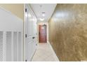 View of the hallway showing the tan wall and white tile flooring at 603 S Ocean Blvd. # 1205, North Myrtle Beach, SC 29582
