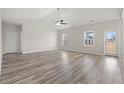 Bright and airy living room with high ceilings, fan, and wood-look floors at 609 Carter Reid Ct., Longs, SC 29568