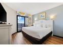 Bright main bedroom featuring a king-size bed, balcony access, and coastal decor for a relaxing vacation at 7100 Ocean Blvd. N # 1425, Myrtle Beach, SC 29572