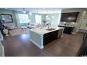 Open-concept kitchen with an island, stainless steel appliances, and view into living area at 860 Ireland Dr., Longs, SC 29568