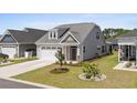 Inviting single-story home featuring a two-car garage, landscaped yard, and charming front porch at 1031 Cascade Loop, Little River, SC 29566