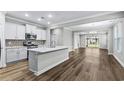 Modern open-concept kitchen with white cabinets, a large island, and stainless steel appliances, flowing into the living area at 1031 Cascade Loop, Little River, SC 29566