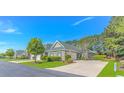 Street view showcasing manicured lawns, matching brick homes, and American flags waving proudly at 139 Chenoa Dr. # D, Murrells Inlet, SC 29576