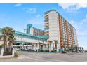 Exterior showcases resort architecture with connecting walkway, palm trees, and vibrant colors creating a captivating coastal scene at 1501 South Ocean Blvd. # 643, Myrtle Beach, SC 29577
