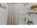 Well-lit bathroom featuring a shower-tub combination with a neutral shower curtain and elegant decor at 1546 Villena Dr., Myrtle Beach, SC 29579