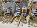 An aerial view of beachfront homes, highlighting a spacious layout with a pool and private beach access at 1611B S Ocean Blvd., Surfside Beach, SC 29575