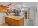 Modern kitchen featuring granite counters, stainless appliances, laundry area, and warm wooden cabinets at 223 Maison Dr. # C7, Myrtle Beach, SC 29572