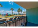 Balcony view of the resort pool area, featuring palm trees, lounge chairs, and beach access at 2301 S Ocean Blvd. # 130, Myrtle Beach, SC 29577
