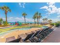 Inviting pool area with lounge chairs, lazy river, and scenic views of the ocean and palm trees at 2301 S Ocean Blvd. # 130, Myrtle Beach, SC 29577