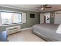 Comfortable bedroom featuring tile flooring, a large window, and a ceiling fan at 2406 N Ocean Blvd. # 803, Myrtle Beach, SC 29577