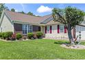 Front lawn and facade with brick and siding details, plus a small garden bed, window boxes, and well-kept grass at 255 Tibton Circle, Myrtle Beach, SC 29588