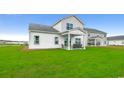 Backyard featuring an attached outdoor patio with two chairs, a bench, and an expansive green lawn at 269 Mayflower Dr., Calabash, NC 28467
