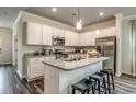 Open kitchen featuring white cabinetry, granite countertops, stainless steel appliances, and a center island with seating at 269 Mayflower Dr., Calabash, NC 28467