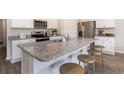 Kitchen island featuring granite countertops, barstool seating, and stainless steel appliances in a modern design at 2884 Riverboat Way, Conway, SC 29526