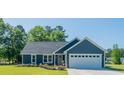 Beautiful single-story home with a blue exterior, well-maintained lawn, and a two-car garage at 294 Field Loop Rd., Georgetown, SC 29440