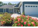 Close-up of a home's front exterior, showcasing flowers and the well-lit two-car garage at 294 Field Loop Rd., Georgetown, SC 29440