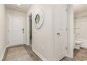 Inviting hallway with wood-look flooring, a white door, and decorative mirror enhancing the home's appeal at 296 Clear Lake Dr., Conway, SC 29526
