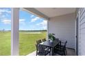 Relaxing covered patio featuring a table and chairs set overlooking a lush green yard and scenic pond views at 304 Clear Lake Dr., Conway, SC 29526
