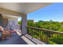 Relax on this outdoor balcony with comfortable seating and a view of lush greenery at 311 71St Ave. N # 5A, Myrtle Beach, SC 29572