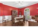 Elegant dining room featuring vibrant red walls, hardwood floors, and classic furnishings at 3157 Hermitage Dr., Little River, SC 29566