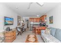 Inviting living room with a couch, dinette, TV, and open kitchen with island and barstool seating at 4516 Seaview St. # 135, North Myrtle Beach, SC 29582